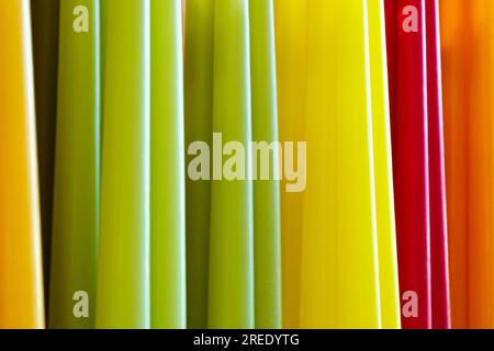Big group of assorted multicolour wax candles, abstract parallel lines vivid background Stock Photo