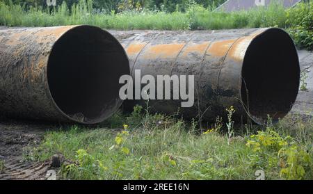 Two rusty old pipes laying on grass. Close up. Stock Photo