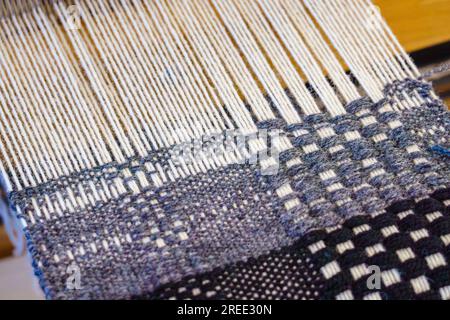 Close-up textile weaving with wool thread yarn on a loom Stock Photo