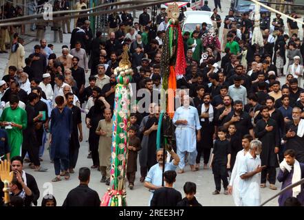 Devotees of Imam Hussain (A.S) are holding religious mourning procession in memories of martyrdom of Hazrat Imam Hussain (AS), grandson of Prophet Mohammad (PBUH), in connection of 8th Muharram-ul-Haram, at Qissa Khuwani Bazar in Peshawar on Thursday, July 27, 2023. Stock Photo