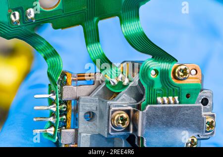 Closeup of green flex printed circuit board on optical pickup of CD-DVD disc drive aluminum part. Electronic laser read-write head on flexible cables. Stock Photo
