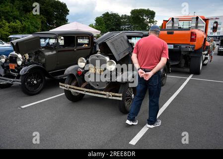 A visitor at an antique and custom car show inspects an unrestored 1930 Model A Ford coupe. Stock Photo