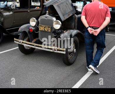 A visitor at an antique and custom car show inspects an unrestored 1930 Model A Ford coupe. Stock Photo