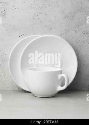 Two white ceramic saucers and one cup on the table Stock Photo