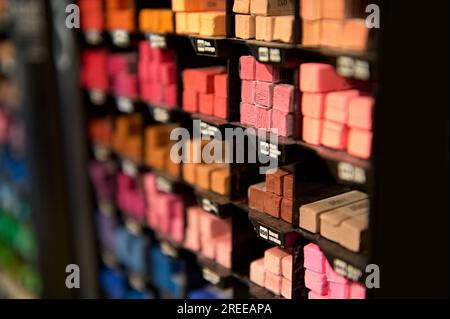 A background of various multi-colored crayons in various shades of red for pastel drawing, for sale in an art store. Stationery store. School statione Stock Photo