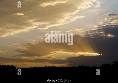 Dramatic cloudy sky with sun rays photographic background Stock Photo