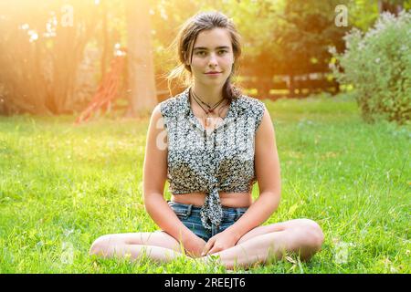 Beautiful teenage girl sitting on a meadow Stock Photo
