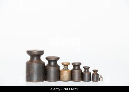 Old rusty weights for scales of different sizes and weights on a white background close-up Stock Photo