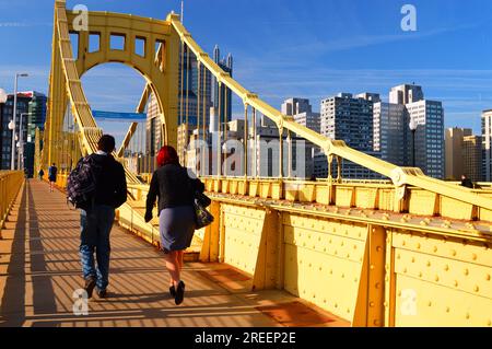 A couple walks across the Roberto Clemente Bridge, heading towards downtown Pittsburgh, Pennsylvania Stock Photo