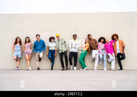 Happy playful multiethnic group of young friends bonding outdoors - Multiracial millennials students meeting in the city, concepts of youth, people li Stock Photo