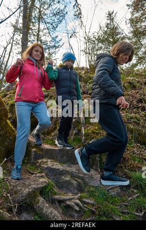 Family hiking in mountains travel adventure vacations group hikers couple with baby trekking outdoor healthy lifestyle eco tourism Stock Photo