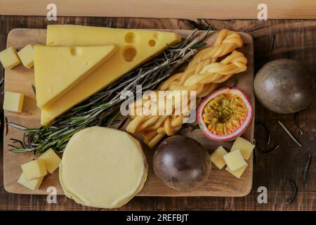 Cheese assorted cut with herbs and fruits.Hard and soft cheeses, rosemary and passion fruit. Mazdar cheese triangles, gouda cheese cubes,chechil Stock Photo