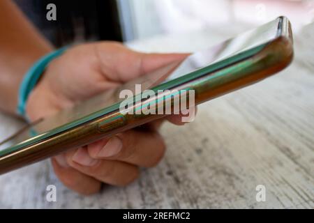 Woman Hand Holding Smartphone on Her Desk. Close up of Hands Woman Using Her Cell Phone Indoor. Stock Photo