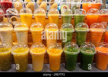 colorful plastic cups with fruit and berry juice at the market, Stock Photo