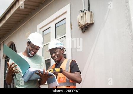 two african electricians work together Stock Photo