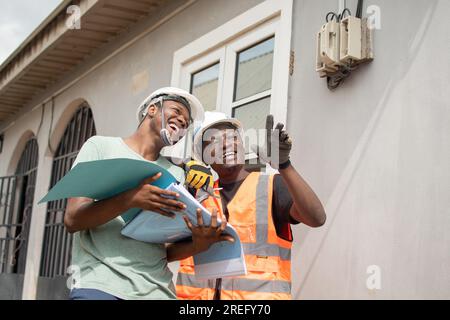 two african electricians work together Stock Photo
