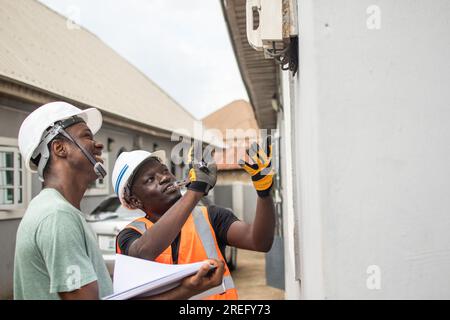 two african electricians working together at a home Stock Photo