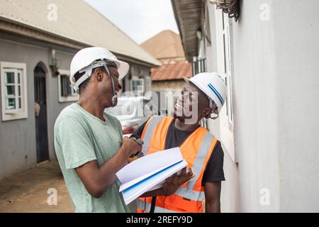 two cheerful african repair men shake hands Stock Photo