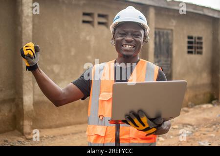 african engineer using his laptop computer rejoices Stock Photo