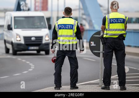 PRODUCTION - 27 July 2023, Brandenburg, Frankfurt (Oder): Two police officers stand at the German-Polish border. More unauthorized entries were registered by the Federal Police at German borders in the first half of 2023 than in the previous year. (to dpa 'Refugee route via Belarus: numbers on the rise again') Photo: Hannes P. Albert/dpa Stock Photo
