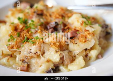 A traditional Czech dish, potato gnocchi , bacon, bacon fat and fried onions, cabbage Sauerkraut Stock Photo