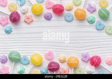Colorful sweet lollipops and candies over white wooden background. Stock Photo