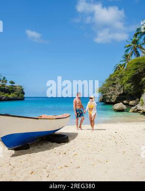 A couple of men and women in swimshorts and bikinis at Playa Lagun Beach Cliff Curacao, Stock Photo