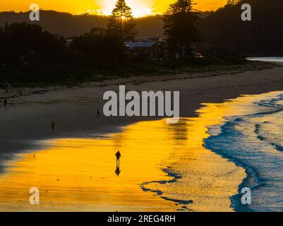 Sunrise with scattered clouds and small waves at Ocean Beach in Umina Beach on the Central Coast, NSW, Australia. Stock Photo