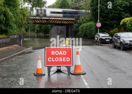 Road Closed road sign in front of  flood water on Crossley Road during storm. Stockport, Greater Manchester UK Stock Photo