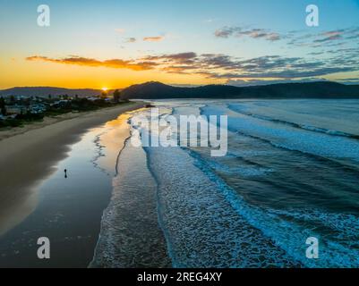 Sunrise with scattered clouds and small waves at Ocean Beach in Umina Beach on the Central Coast, NSW, Australia. Stock Photo