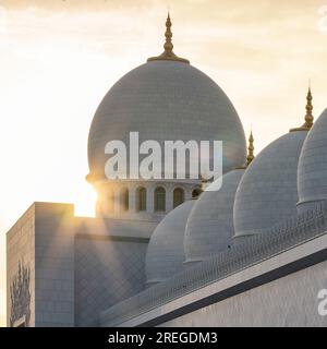 Sunstar against the Dome of Sheikh Zayed Mosque during Golden hour Stock Photo