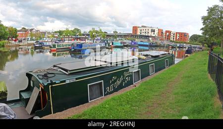 Narrowboat moored in the foreground at Northwich Marina basin with other canal boats and waterside development in the background, Northwich, CW9 5HD Stock Photo