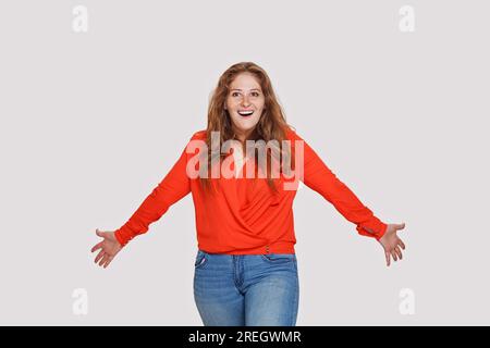 Curvy woman with hand in pocket standing in front of wall Stock