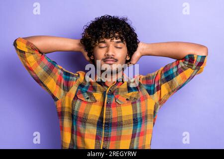 Portrait of young chilling guy after discotheque hangover relaxation wear plaid shirt stylish costume isolated on violet color background Stock Photo