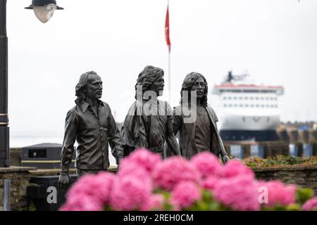 Bronze statue on Douglas promenade erected to celebrate the Bee Gees born on the Isle of Man. Steam Packet Company flagship, Manxman in the background Stock Photo