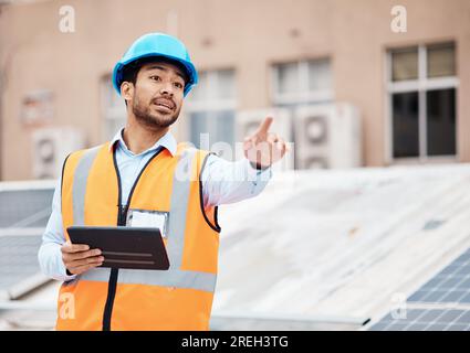 Tablet, planning and male construction worker on a rooftop of a building for inspection or maintenance. Industry, engineering and young man foreman Stock Photo