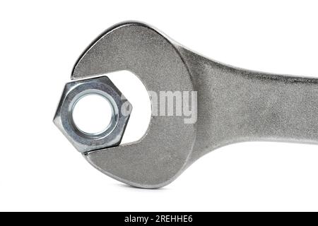 Close-up steel screw nut clamped in a wrench on white background Stock Photo