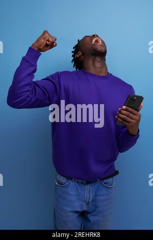 lucky winner american young man with dreadlocks in studio background Stock Photo
