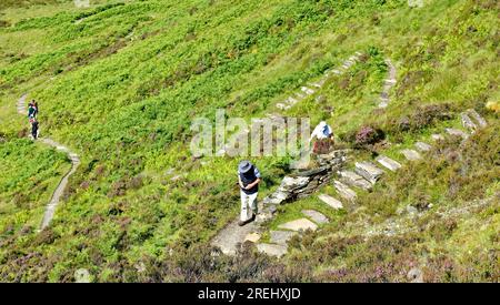 Knockan Crag West Highlands Geopark Scotland walkers on the stone steps of the downhill footpath Stock Photo