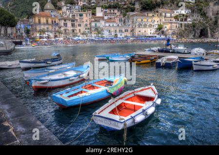 Cetara, Italy - June 17, 2018: Small fishing boats at Cetara, Italy on the Mediterranean Coast near a tourist filled beach. Stock Photo