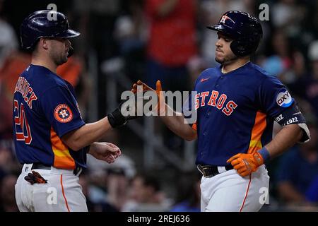 Los Angeles Dodgers' Jonny Deluca, center, is congratulated by Miguel  Rojas, right, after scoring on a balk as Houston Astros catcher Yainer Diaz  kneels at the plate during the eighth inning of