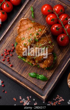 Delicious crispy croissant with salmon, lettuce, cheese and tomatoes on a dark concrete background Stock Photo