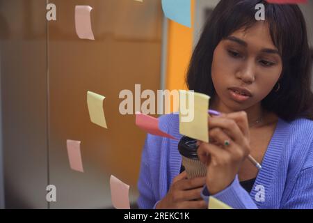 Young female making notes in modern room Stock Photo