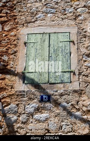 old green painted wooden shutters on a stone barn in the mediterranean town of split in croatia. Stock Photo