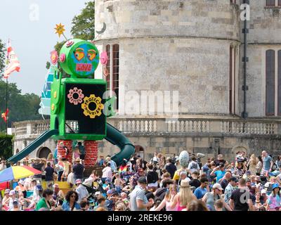 Lulworth, UK. 28th July, 2023. Crowd seen standing under a green monster next to Lulworth Castle while watching North American performance art comedy disco duo from Minneapolis, Minnesota, Koo Koo Kanga Roo performing live on stage at Camp Bestival. Camp Bestival is a family centred festival run by DJ Rob Da B and his wife Josie Credit: SOPA Images Limited/Alamy Live News Stock Photo