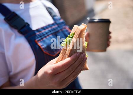 Building engineer has lunch break, eating sandwich and drinking coffee Stock Photo