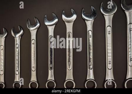 A set of combination spanners of various sizes photographed against a dark background . Stock Photo