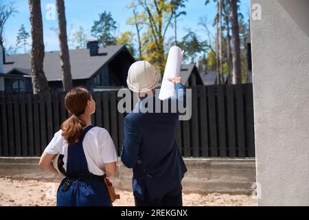 Back view male architect showing something to woman engineer Stock Photo