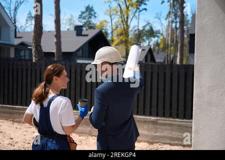 Colleagues builders discussing constraction site project during coffee break Stock Photo