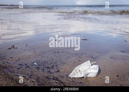 Discarded face mask on the beach Baltic Sea Stock Photo